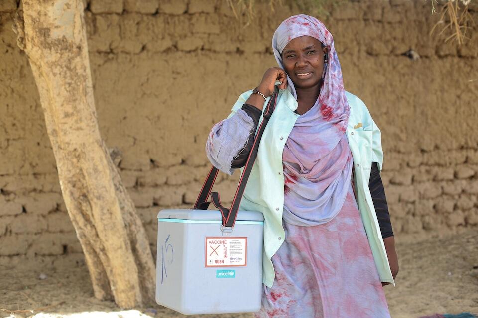 Djouma Keidalla, an obstetrician at a health center in Sankoré, carries a cooler containing tetanus vaccines in the village of Bakaiwait, Mali.