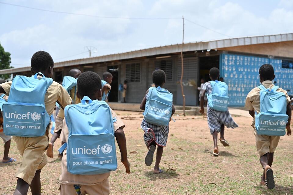 Children carrying UNICEF backpacks head back to class from the playground outside their school built with recycled plastic bricks in Sakassou central Côte d’Ivoire.