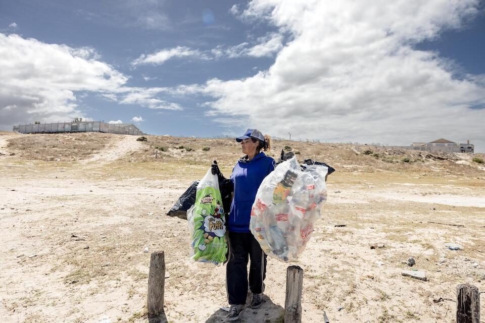 A woman in South Africa carries recyclable waste to a drop off point to help combat climate change.