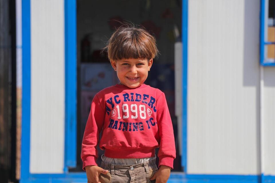 Muhannad stands outside the UNICEF-supported early childhood education center called ‘Dream’ at Ain Khadra IDP camp in Al-Malikiyeh, Al-Hasakeh, Syria, on Sept. 21,  2023.