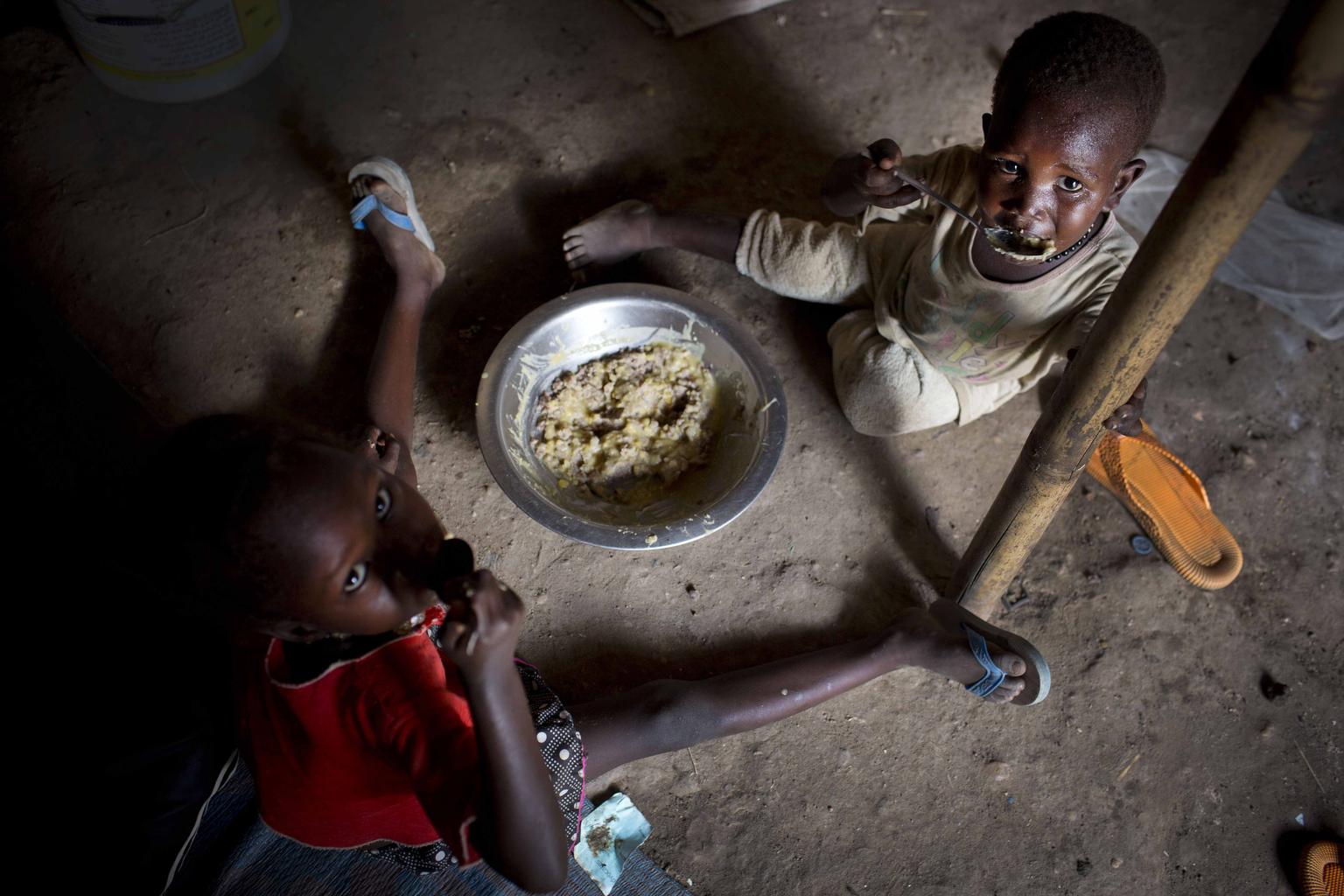 Children displaced by recent fighting eat their daily meal at a displacement site in Juba. © UNICEF/NYHQ2014-0344/Kate Holt