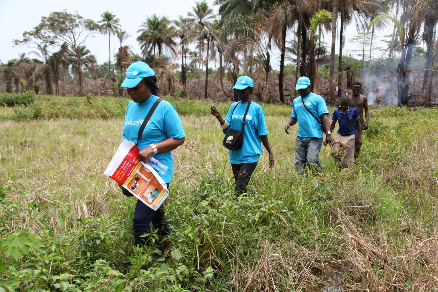 In Liberia, UNICEF workers travel by foot to reach plantation workers in a remote area, where they will share information on the symptoms of Ebola virus disease (EVD) and best practices to help prevent its spread,