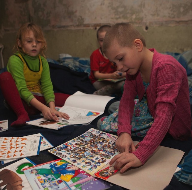 On 20 February, children play with materials from a UNICEF Ukraine education kit, in a bomb shelter, in the city of Donetsk in Donetsk Oblast.