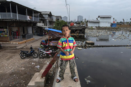 Satrio, 7, stands on a sea wall near his home in the Muara Baru neighborhood of North Jakarta, Indonesia.
