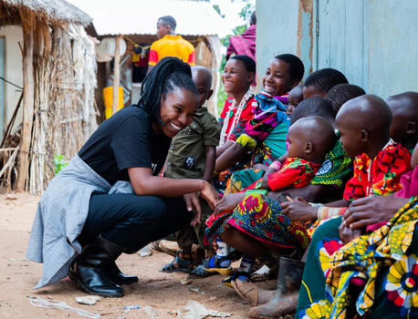 A UNICEF-supported community health worker smiles at a young child awaiting care services during an outreach session in Masiano sub-village, Chunya district, Mbeya region, southwest Tanzania.