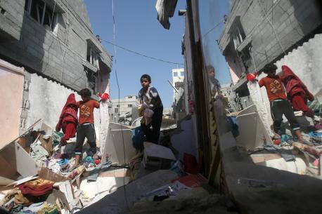 On 10 July 2014, boys carry clothing salvaged from the rubble of the Al Haj home, which was destroyed during an early morning Israeli air strike in the Khan Yunis refugee camp in the southern Gaza Strip. © UNICEF/NYHQ2014-0905/El Baba