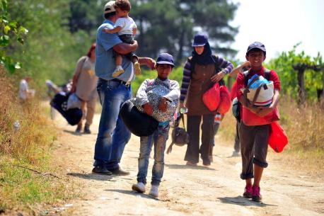 Migrant children, women and a man walk along a dusty path from the Greek border to the reception centre near the town of Gevgelija, Macedonia. Europe is struggling to handle the global migrant crisis exacerbated by conflict in the Middle East and North Af