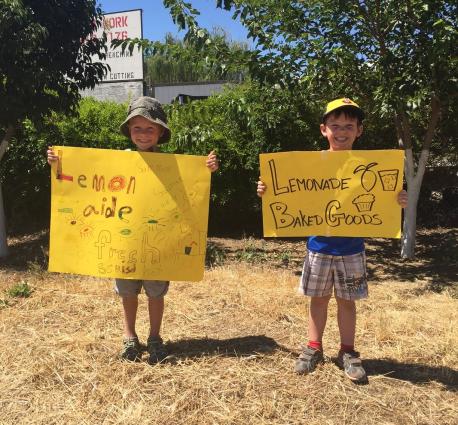 Children Hold Up Lemonade Stand Signs