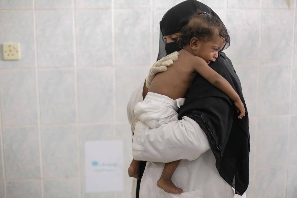 Health worker Hana’a holds 8-month old Jouri in UNICEF supported health facility of AlHussainya, Hudaydah, Yemen, September 2022.
