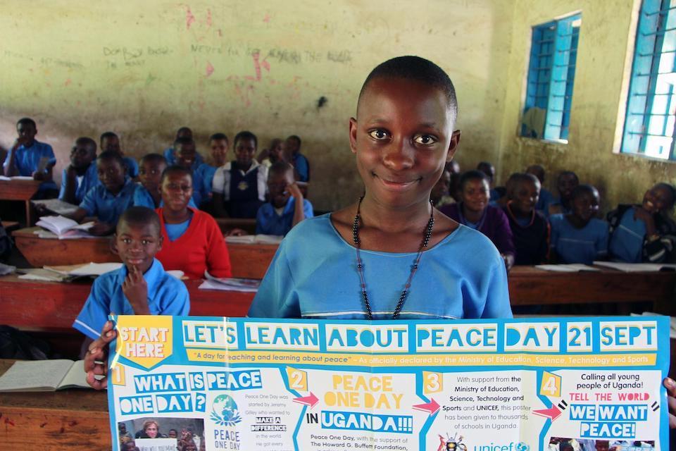 Ritah Sharon Bira, a P.4 pupil of Buhundu Primary School in Bukonzo sub-county, Bundibugyo District, Western Uganda, displays a peace poster to assist pupils in her class learn about the International Day of Peace observed annually on Sept. 21.