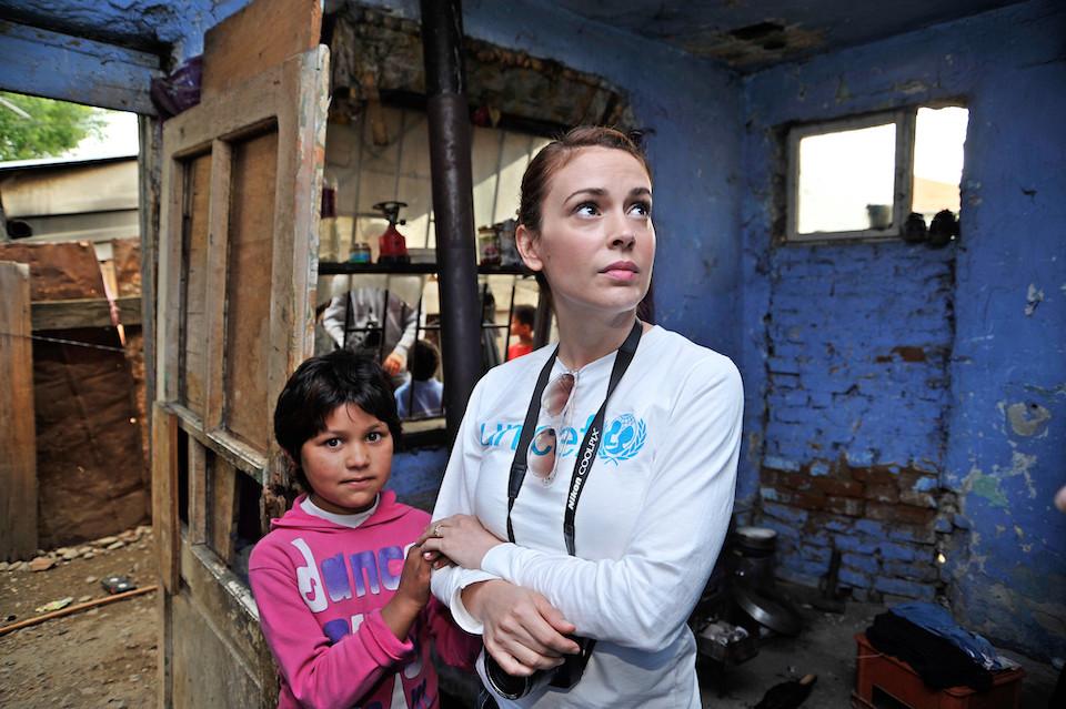 UNICEF Ambassador Alyssa Milano in Kosovo in 2009 with a child being helped by UNICEF.