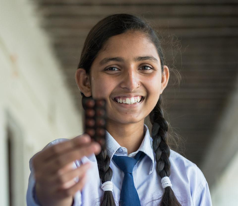 Shalu, 15, a student at Sarvodaya School in Saptari Shalu Kumari Sah, Nepal, holds a packet of iron and folic acid supplements she received through a UNICEF-supported government nutrition program for adolescent girls. 