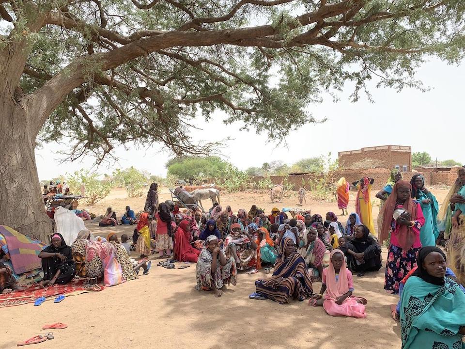 On April 27, 2023, women and children fleeing conflict in Sudan rest under a tree in Koufroun, Chad. 