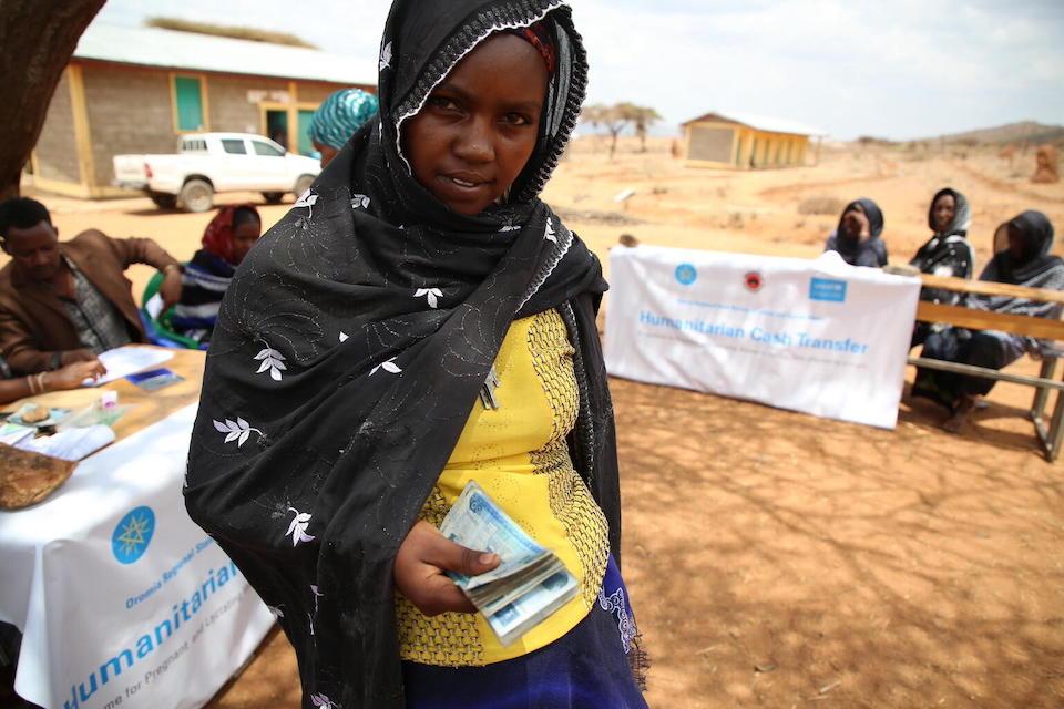 A young Ethiopian woman holds cash she received from UNICEF