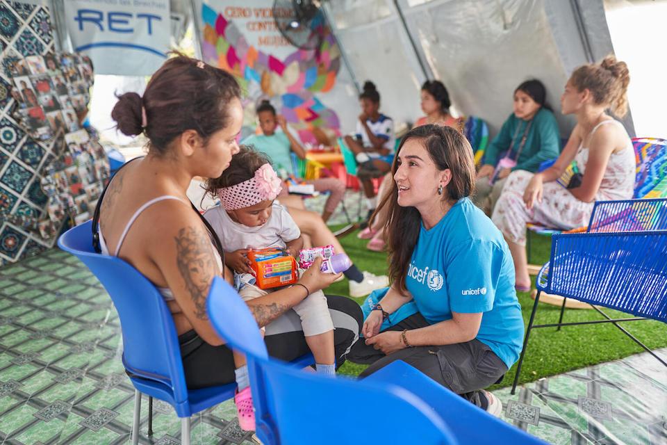 Johanna Tejada, Gender-based Violence and Protection Against Sexual Exploitation and Abuse Specialist with UNICEF Panama, right, speaks with a migrant mother and her child in a Self-Care Space in Lajas Blancas, Darien, Panama. 
