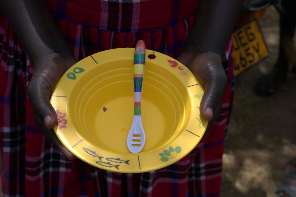 A mother holds a feeding bowl provided by UNICEF that is specially designed to include reminders about what to feed young children to support good nutrition..