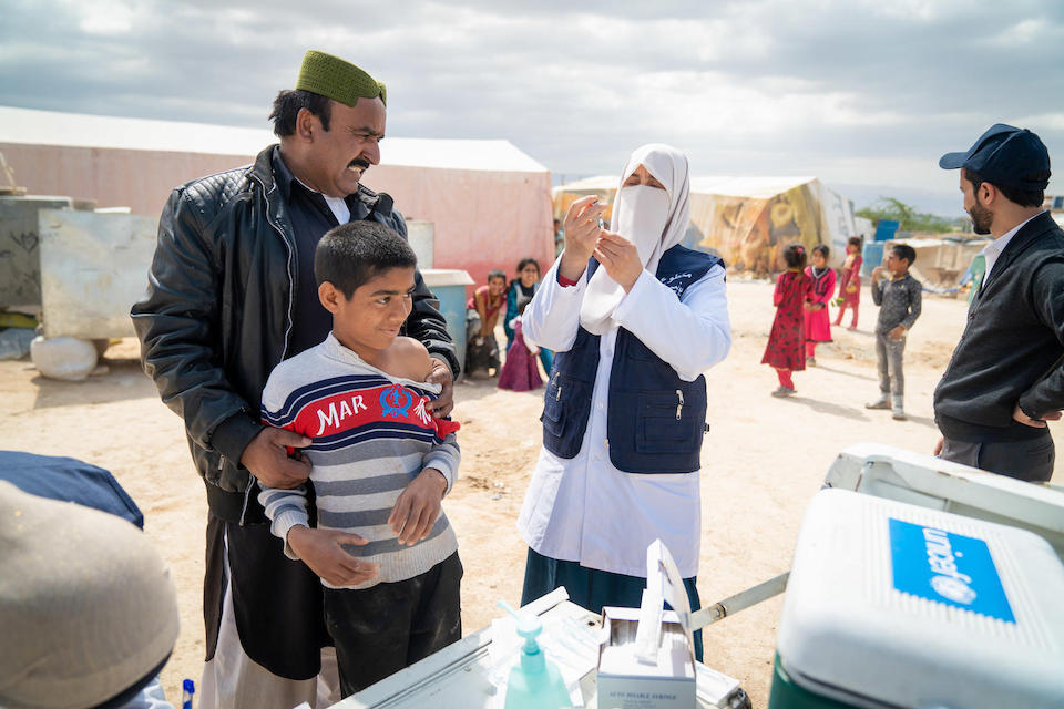 Children in an informal tented settlement in Jordan receive vaccinations from a mobile health team supported by UNICEF. 