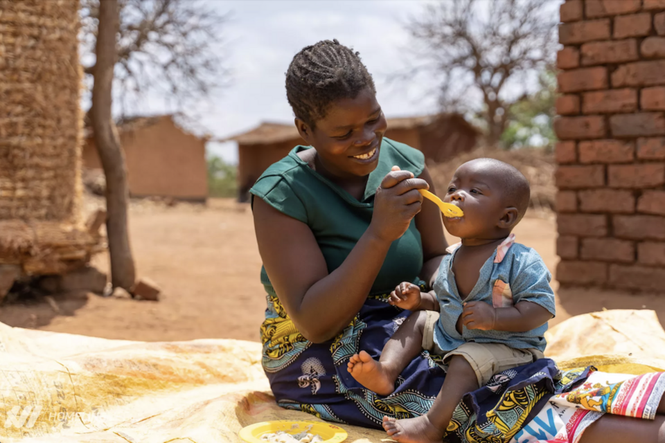A mother feeds her child a nutritious meal in Barton Village, Karonga district, Northern Region, Malawi. 