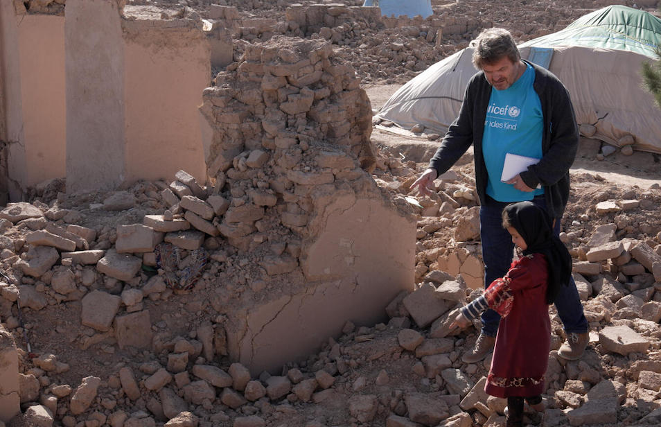 Adina, 8, shows Daniel Timme, UNICEF Afghanistan's Chief of Communications, all that remains of her family home, destroyed by an earthquake in Oct. 2023.