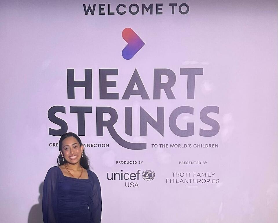 Trisha, 18, a high school senior and UNICEF USA Youth Representative from Southeast Texas, stands beside a sign at the Heart Strings experience-for-good in Houston..