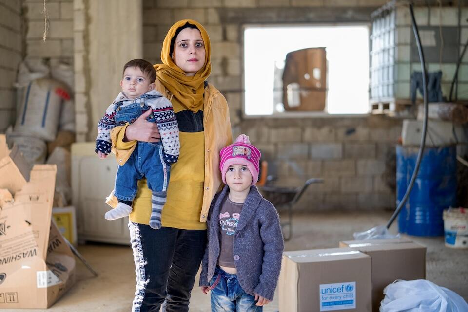 A mother stands with her children, 7 months old and 5 years old, in Beirut after being displaced from southern Lebanon