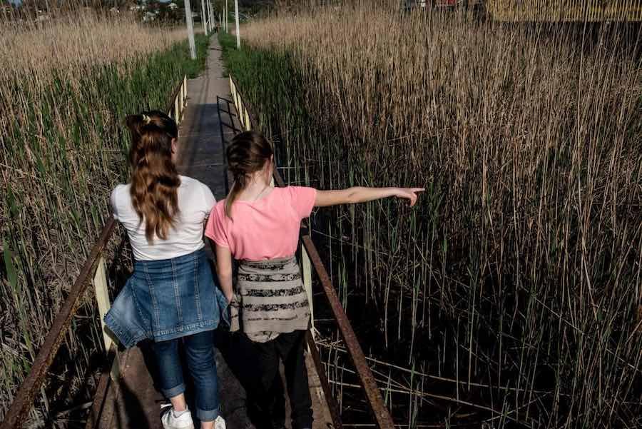 Two Girls Walking Over Bridge