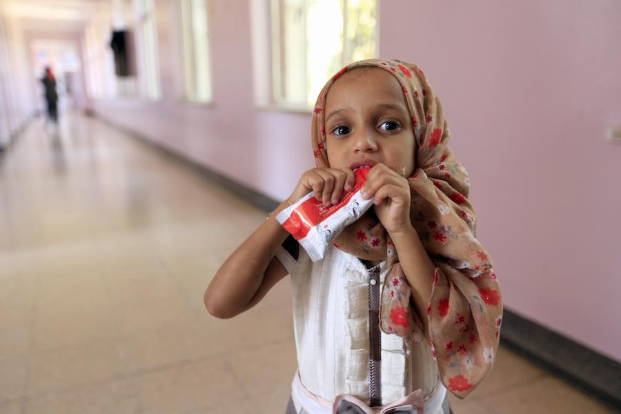 A girl in Sa'ana, Yemen is given Ready-to-Use Therapeutic Food (RUTF), a high-protein peanut paste, as treatment for malnutrition. 