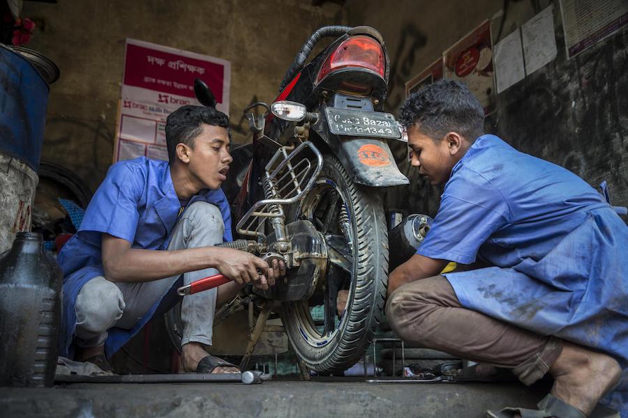 Mohammed (left) and Biplob, both 18, work on a motorbike in a UNICEF-supported job skills training program in Court Bazar in the Cox's Bazar district of Bangladesh in February 2019.