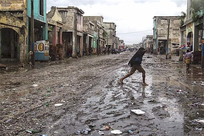 On 4 October 2016, a woman crosses the street in downtown Port au Prince after Hurricane Matthew passed over Haiti.
