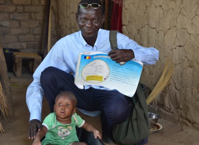A community relay member reviews a child’s vaccination status using the community register in Sarh, Chad