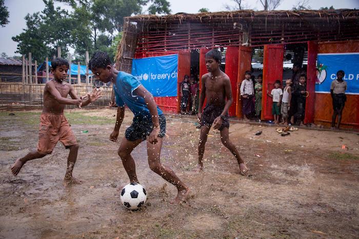 Rohingya children play in the rain outside a UNICEF-supported Child-Friendly Space in a refugee camp in Bangladesh after escaping horrific violence in neighboring Myanmar. 