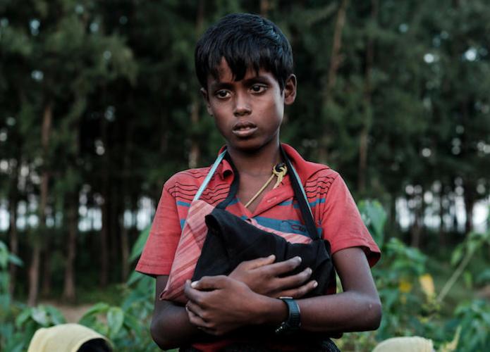 In Cox's Bazar, Bangladesh, 10-year-old Rohingya refugee Mohammed clutches two copies of the Holy Quran, the only belongings he has left after he fled ethnic violence in Myanmar in 2017. 