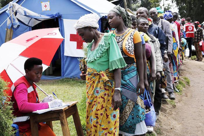 A Uganda Red Cross volunteer registers a woman as people from Democratic Republic of Congo line up at a UNICEF-supported screening facility at a point of entry at Uganda-DRC border town of Bunagana in Kisoro district in 2019.