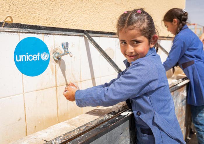 To prevent the spread of the novel coronavirus, Dareen, 6, washes her hands at a wash station set up by UNICEF in Jordan in 2020.