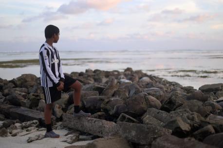 Ahmed Anjal bin Anis, 9, at a beach in Dhiffushi, Maldives. His school suffers from regular sea water flooding due to sea level rise. “But even if the school gets flooded, I still want to go,” he says. Dhiffushi, Maldives, October 2021