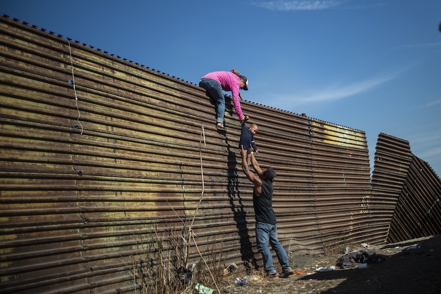 Central American migrants climb the border fence between Mexico and the United States, near El Chaparral border crossing, Tijuana, Baja California, Mexico, on November 25, 2018.   