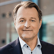 bust portrait photo of Alexander Lacik, a close cropped brunette man in a suit with no tie