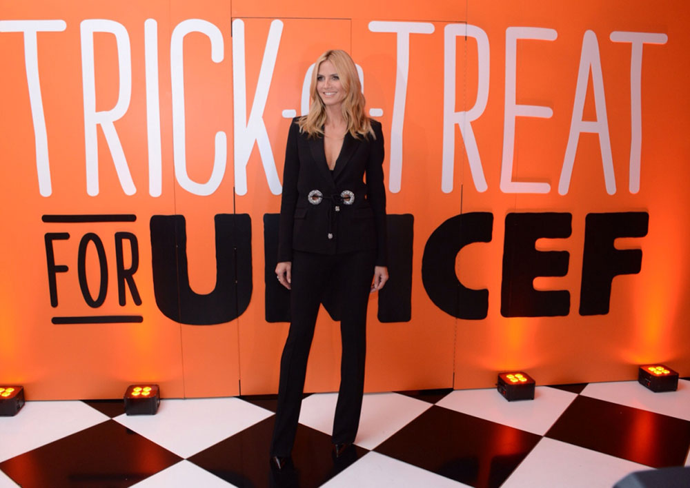 Heidi Klum, longtime Trick-or-Treat for UNICEF supporter, poses in front of a large Trick-or-Treat mural.