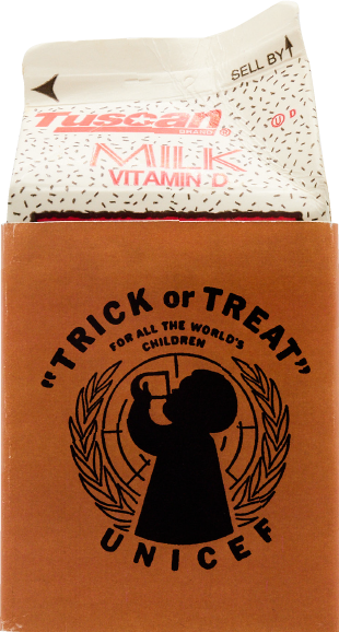 A Trick-or-Treat for UNICEF orange sign with a child silhouette in the UN emblem, attached to a milk carton