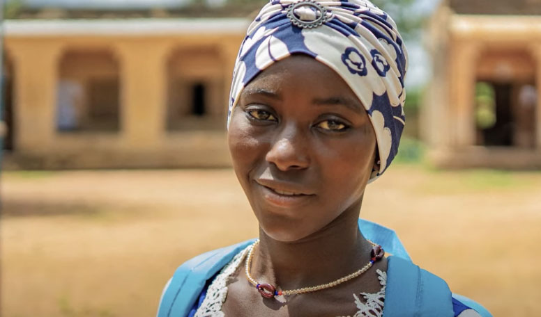A profile pic of Safiatou, who stands outside in a head wrap.