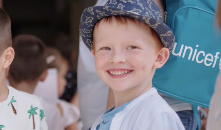 A profile pic of Andrei, a young boy in a knit hat who smiles at the camera.