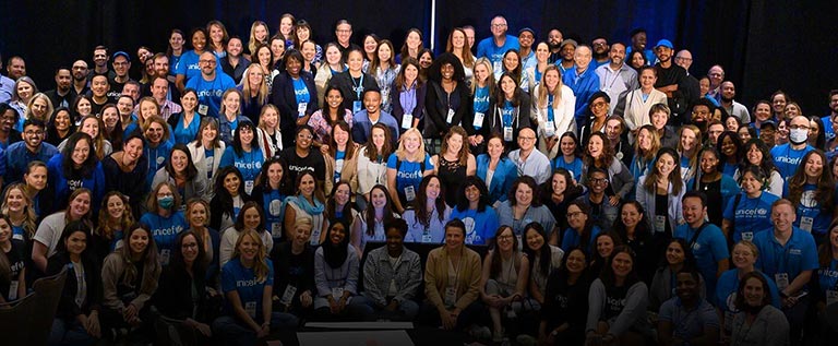 a large school class-like shot of a large, diverse group of over 100 UNICEF employees
