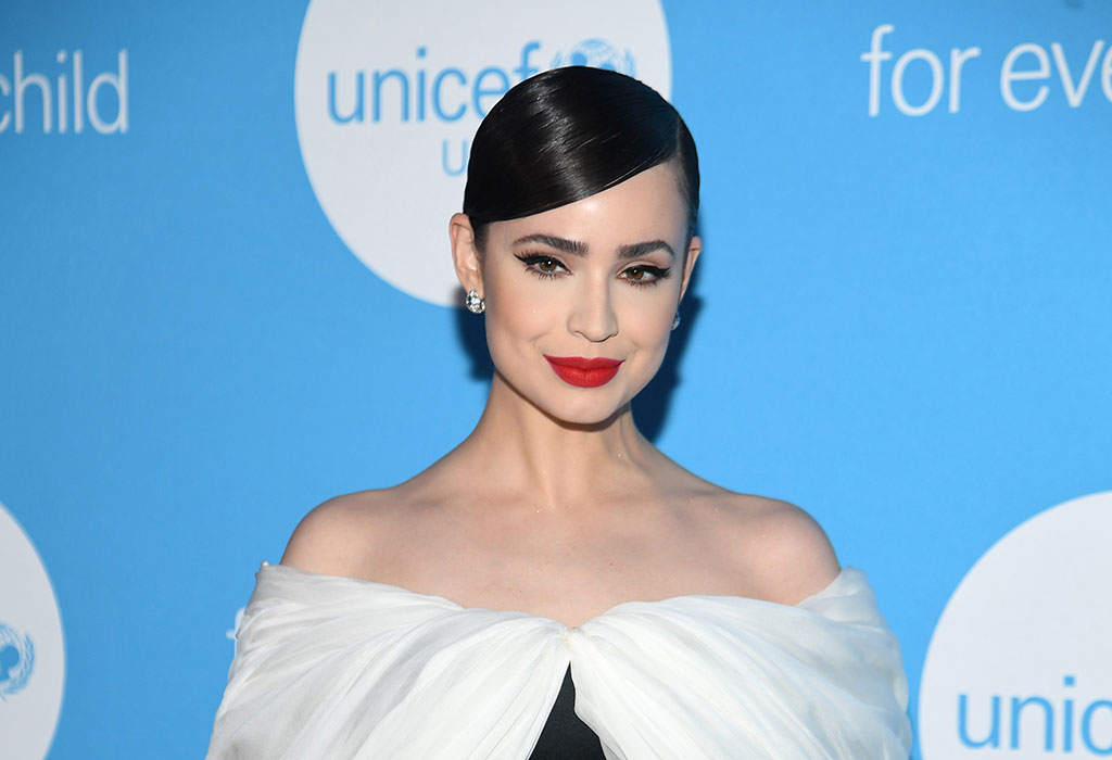 Sofia Carson posing on the UNICEF USA blue carpet in a strapless dress