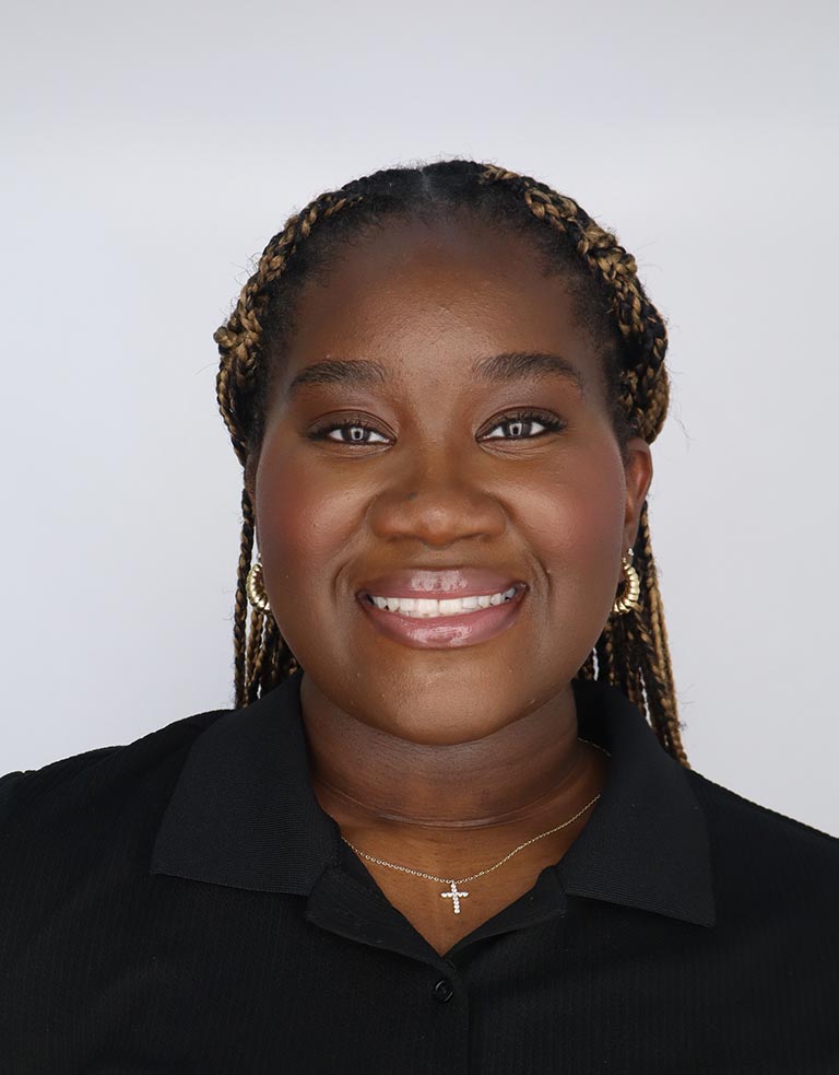profile photo of Samiaht Busari, in tied-back braids and a black dress shirt.