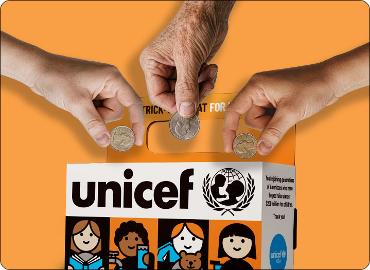 Three hands each about to deposit a quarter into the Trick-or-Treat for UNICEF box.