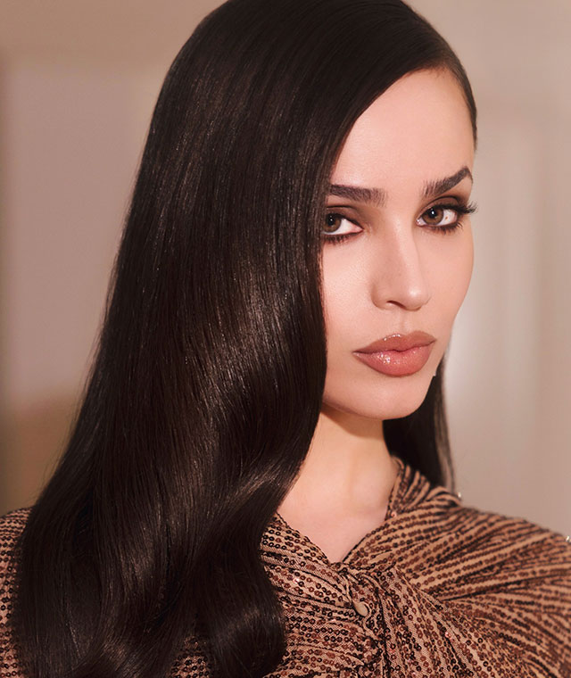 Profile of Sofia Carson with her long hair down next to her face.