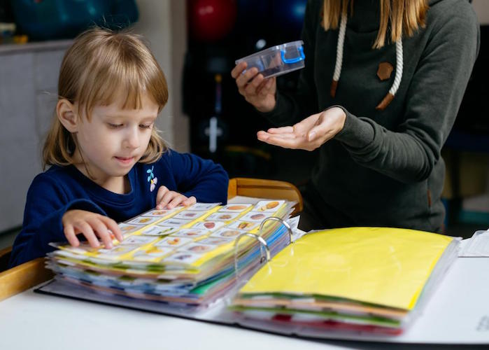 Theona, 4, who has autism spectrum disorder, uses picture cards to communicate with friends and family in Lviv, Ukraine. 