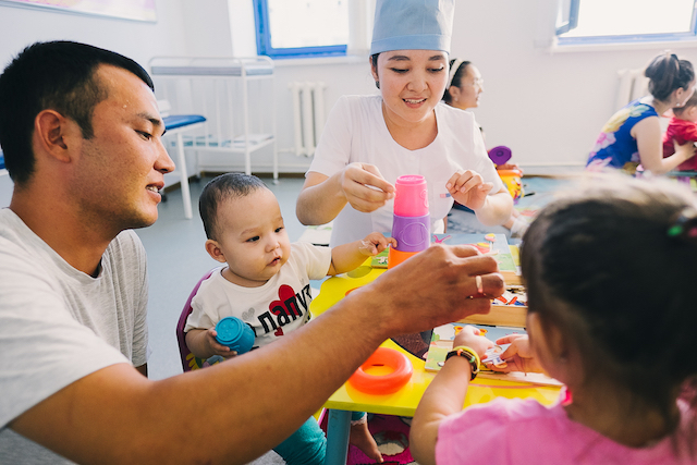 A father plays with his kids in a UNICEF early childhood program in Kyzylorda, Kazakhstan.