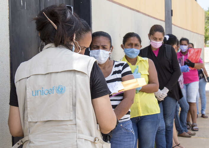 Mothers in Zulia state, Venezuela line up to receive food kits and other urgently needed supplies distributed by UNICEF staffer Maura De Moya (far left) and colleagues.