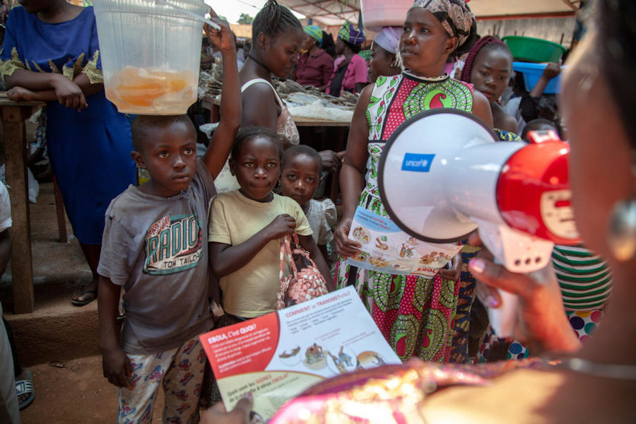 In August 2018, a member of UNICEF's Ebola outreach team addresses children and parents in Ebola-hit Beni in North Kivu, Democratic Republic of the Congo.